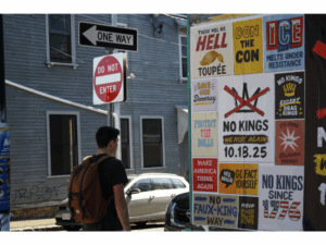 Someone walks past anti-ICE signage by Somerville Avenue in Somerville, MA, Oct. 5, 2025. Photo by Christopher Morris. Copyright 2025 Christopher Morris.