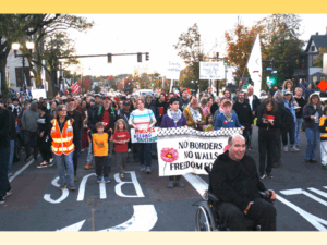 People marching on Broadway in East Somerville to support immigrants targeted by U.S. Immigration and Customs Enforcement on Oct. 21, 2025. Photo by C. Scott Morris. Copyright 2025 C. Scott Morris.